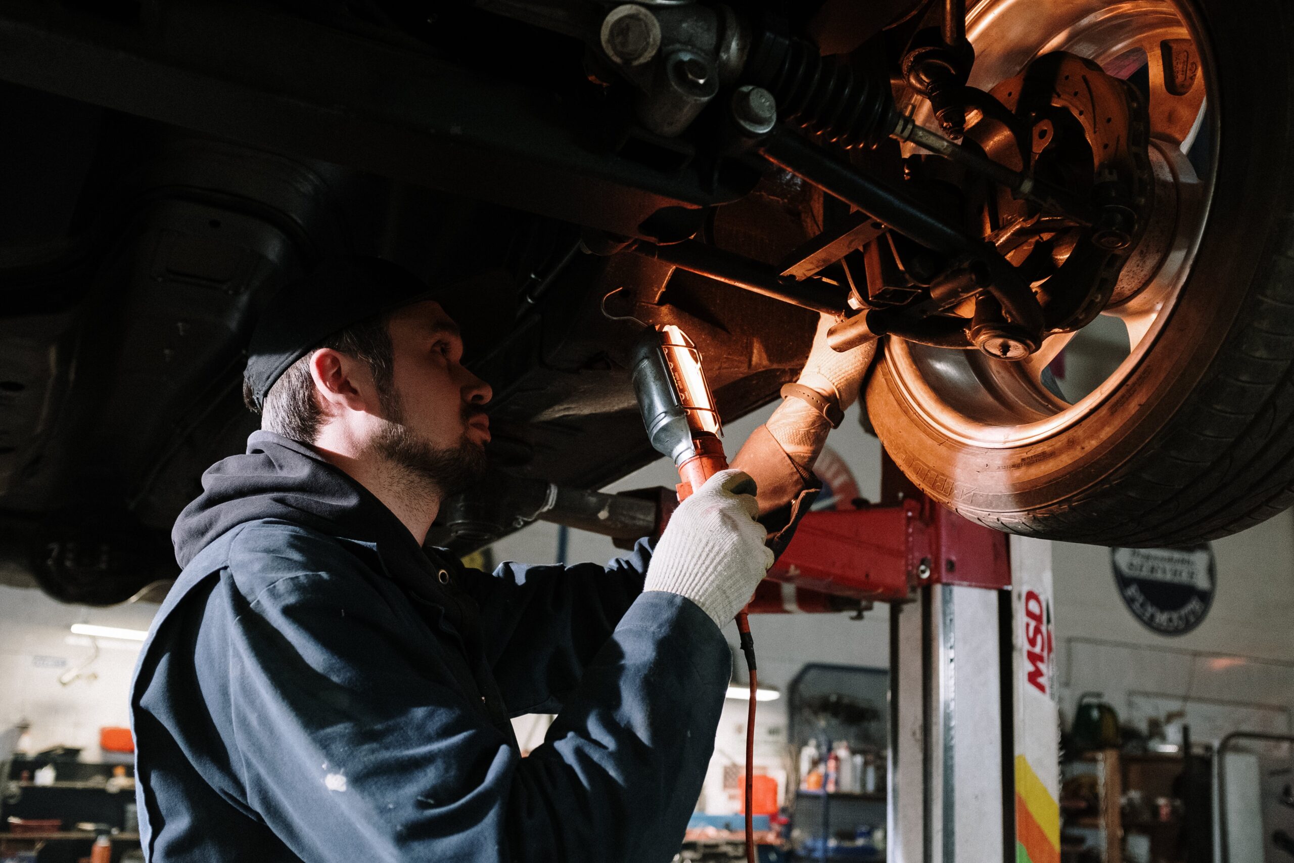 mechanical worker examining car tire